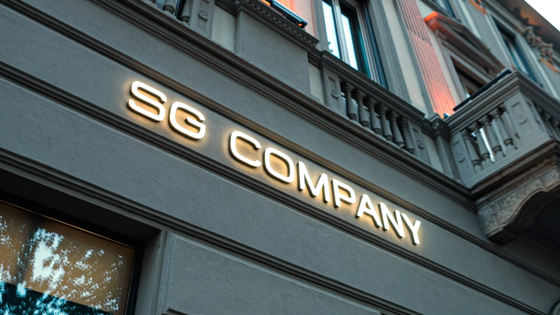 Dettaglio dell’ingresso della sede di SG Company con logo e porte principali.